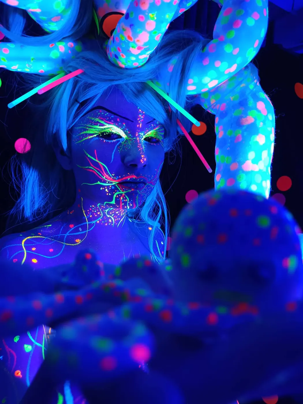 Caracterización de fantasía con pintura corporal de neón azul y violeta